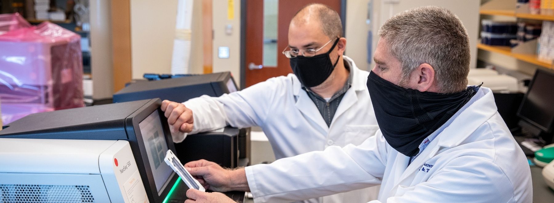 UMMC scientists Dr. Ashley Robinson, back, and Dr. Michael Garrett, front, prepare COVID-19 samples for genomic sequencing, a tool that allows researchers to distinguish between virus variants in order to determine which are more or less prevalent in the population.